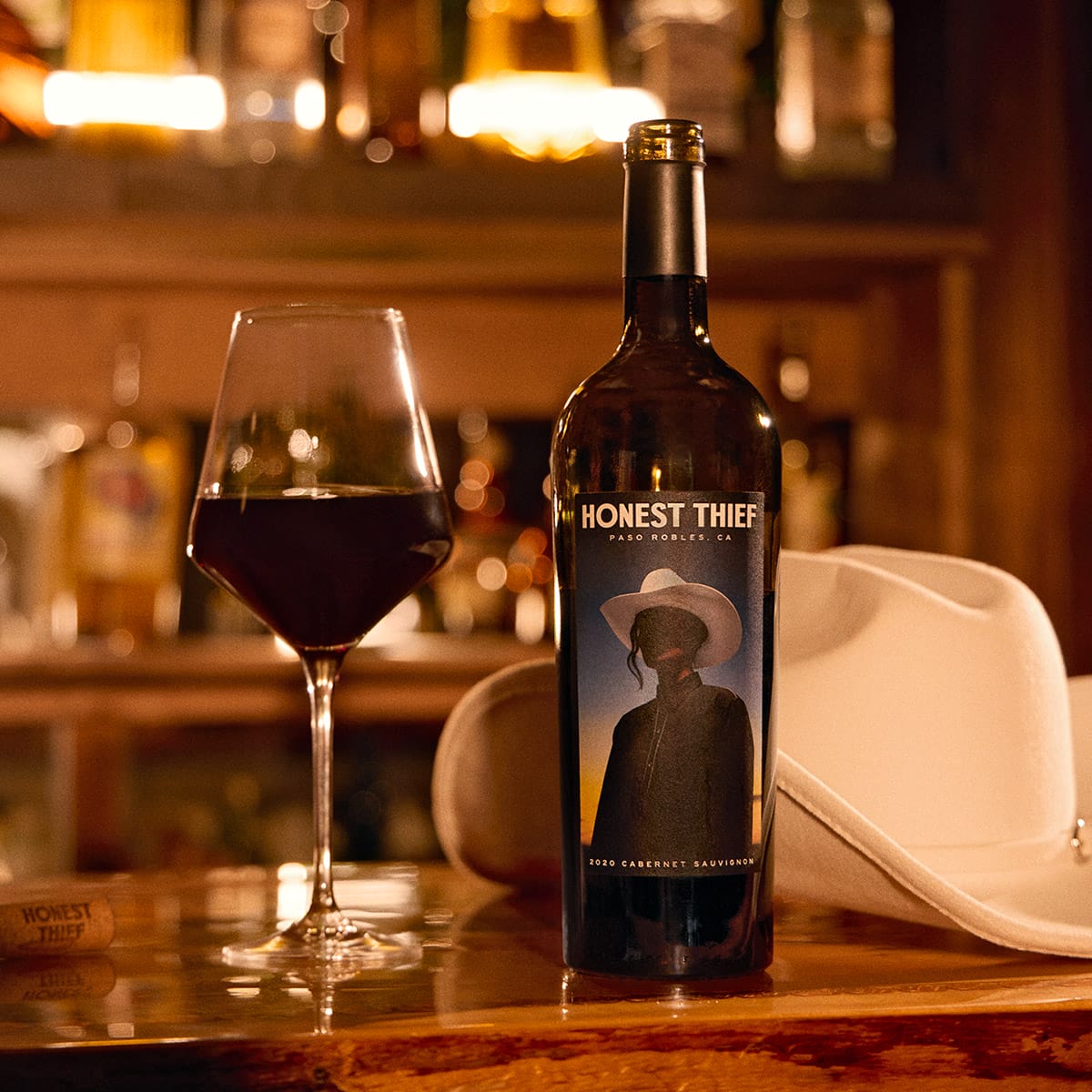 Honest Thief wine bottle on bar with filled wine glass